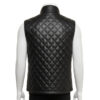 Detailed view of the diamond quilting and snap button closure on a leather puffer vest.
