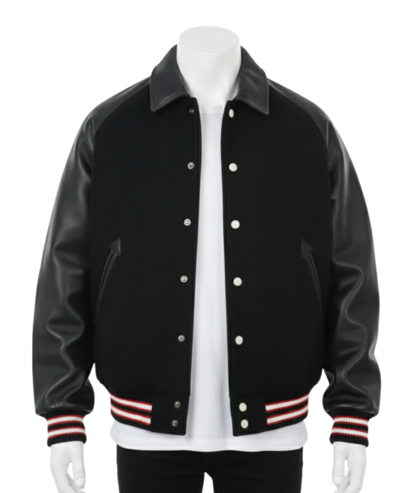 A man wearing a black and white leather varsity jacket with a wool body and snap buttons.