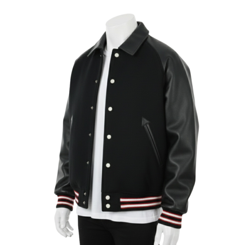 A man wearing a black and white leather varsity jacket with a wool body and snap buttons.