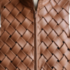 A handcrafted cognac interlaced leather gilet women showing the womens brown leather vest texture.